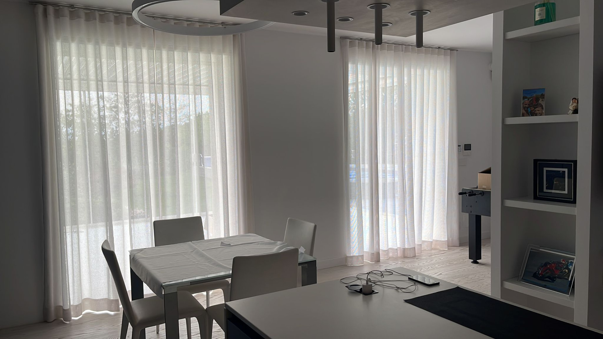Ambiente contemporaneo con grandi vetrate schermate da tende leggere